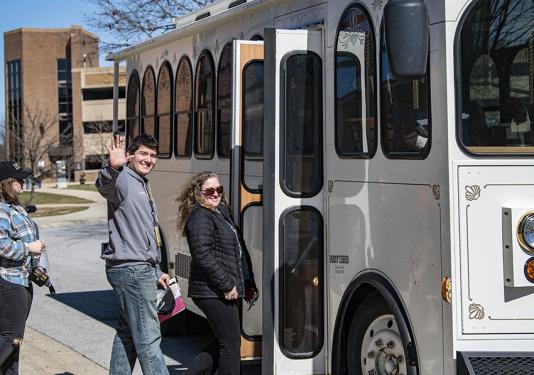 A prospective student is boarding a trolley.
