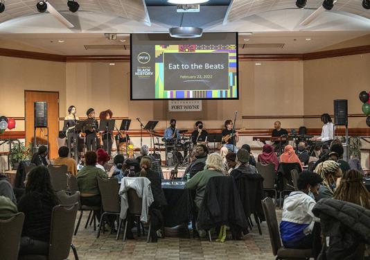 Students enjoy a soul food meal while listening to student performers