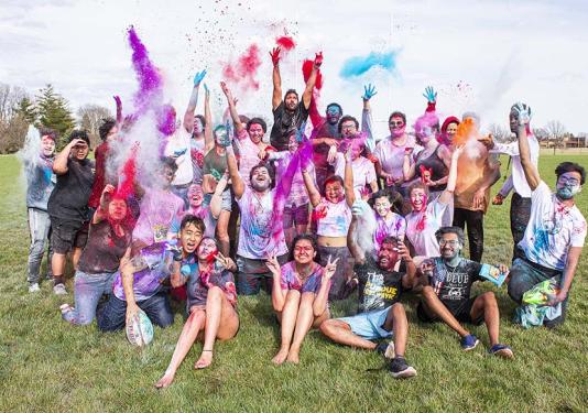 Students celebrate spring by throwing colorful powder
