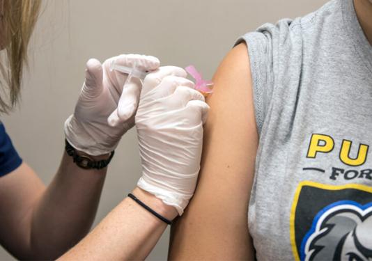 Nurse administering flu shot to PFW student