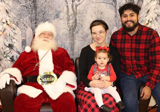 A family visits with Santa Claus at the Adopt-a-Don Jingle Jubilee dinner