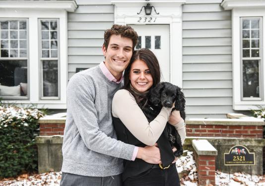 Julia Green and her husband are standing in front of their home