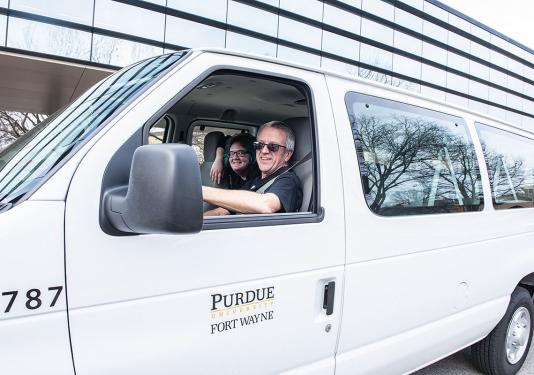 A driver is dropping off students on campus.