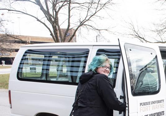 A student is entering a shuttle van at Purdue Fort Wayne