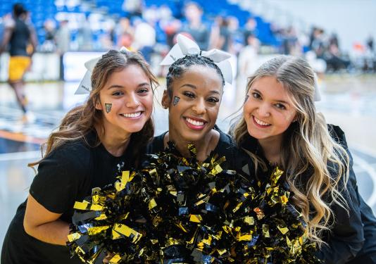 Three PFW cheerleaders are smiling