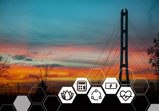 Sunset with variations of blue, pink, and orange sky behind the sihouette of Venderly bridge