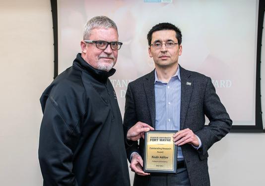Carl Drummond presents the Outstanding Research Award to Nadir Adilov