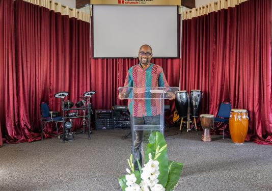 Francois Mikobi is standing at the lectern in church.