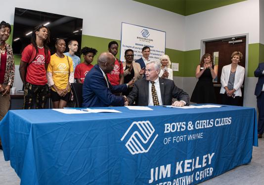 Joe Jordan, president and CEO of the Boys & Girls Clubs, and Chancellor Ron Elsenbaumer of PFW sign the paperwork to officially usher in this next chapter of collaboration between the two entities.