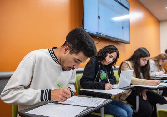 Students writing and working on assignments in class.