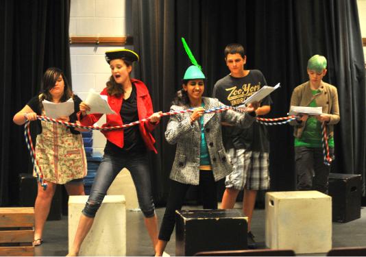 kids acting on stage with funny props
