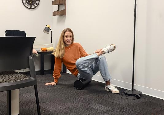 Health coach using a foam rolling to stretch tight muscles for the 10-minute foam rolling workout.