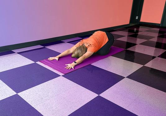Health coach and yoga instructor demonstrating child's pose yoga stretch