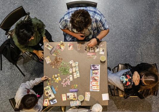 Four people are playing a board game