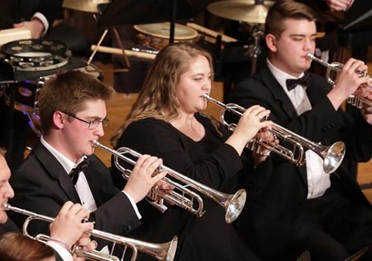 students playing trumpets on stage