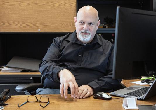 Portrait of Ron Herrell sitting behind a desk