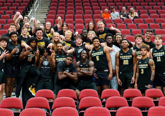 Group photo of The Herd with members of the PFW men's basketball team.