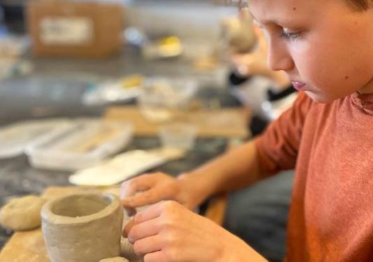child making pottery