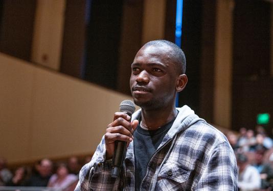 An honors student asks a question at an Omnibus Speaker Series presentation.