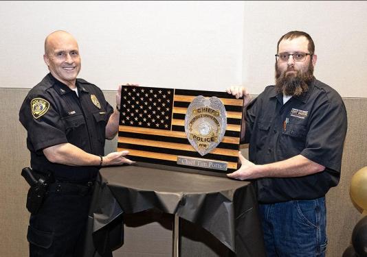 Chief Tim Potts is being presented with a plaque