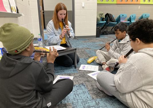 Maddy Urbahns teaching a 5th grade music class to play the recorder.