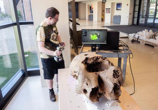 Graham Fredrick, library systems specialist, was part of a team including Erika Mann, director of library technology and digital initiatives, and Daniel Lin, information services technician, who scanned the baby mastodon’s skull for 3D digitization.