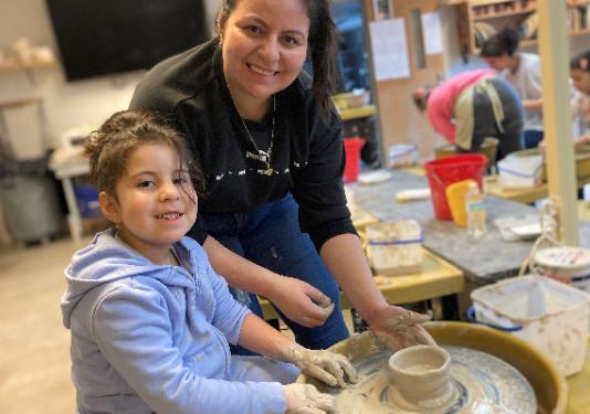mother and daughter making pottery