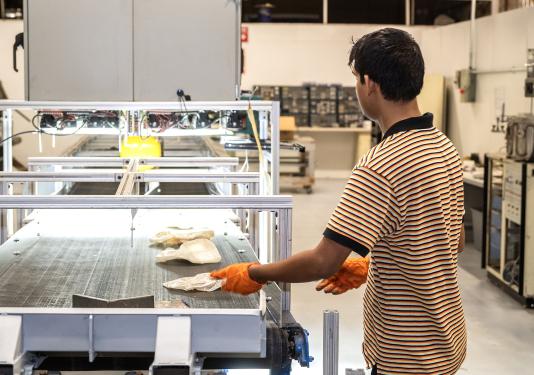 Placing crushed bottles on the conveyor belt.