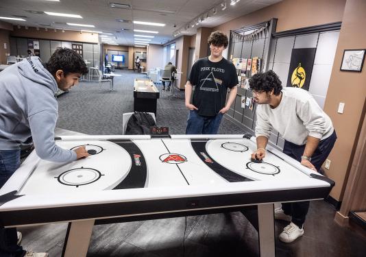 Students are playing air hockey
