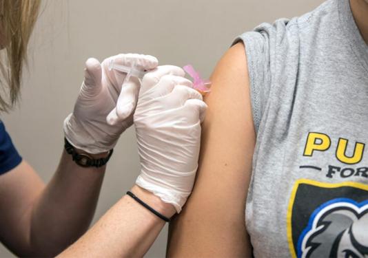 A student receiving a flu shot. 
