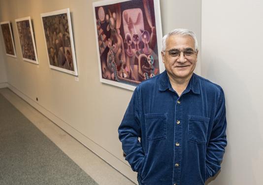 Andres Montenegro standing next to an art exhibit