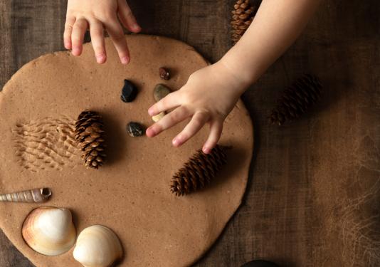 child making clay creation with nature objects