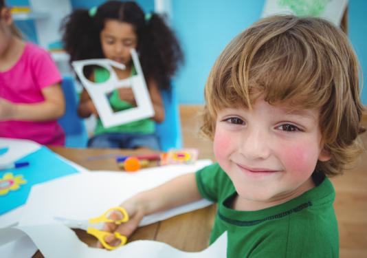 child making paper creation with scissors