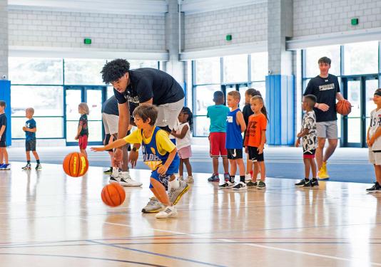 A PFW athlete is teaching at a children's basketball camp