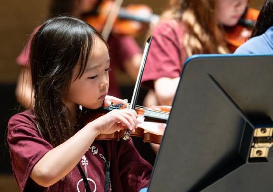 young child playing violin