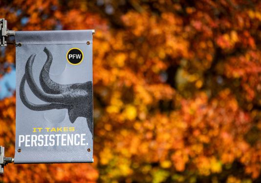 A mastodon banner backed up by fall foliage