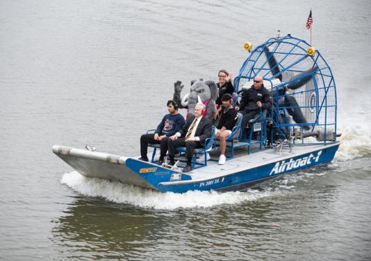 Airboat on the river with multiple people on it including the Mastodon