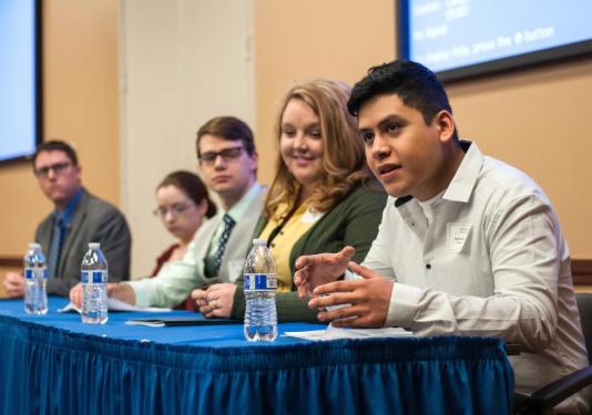 History Conference students sitting at a table answering questions from audience members.