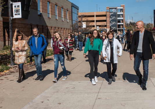 Students and their families are walking down the sidewalk