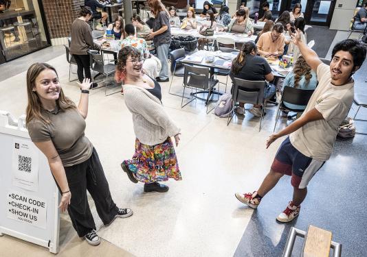 Two students are inviting the viewer to their craft club