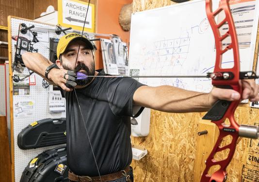 Cadd Amsler is drawing back an arrow