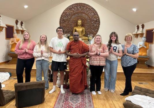 Sociology students with a Buddhist monk in a temple