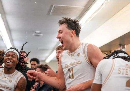 Men's basketball team members celebrate a win