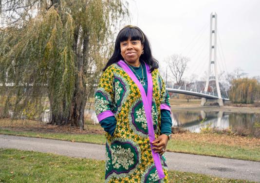 Stacy Abraham is on campus standing near a bridge