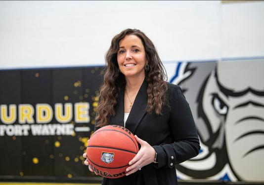 Coach Maria Marchesano is holding a basketball