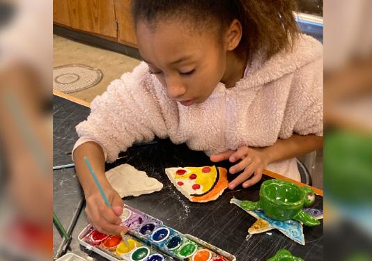 child painting pottery