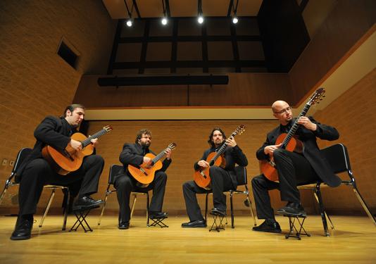 men in circle playing guitar