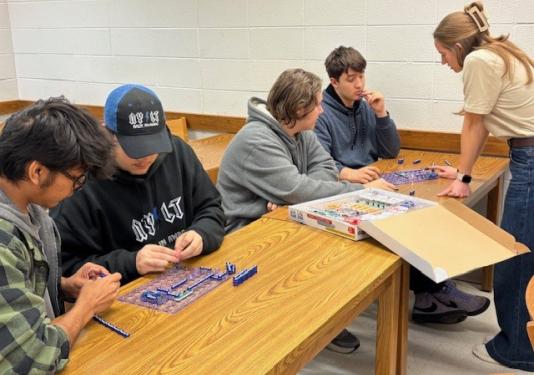 High school students doing circuit connection activity with student ambassador