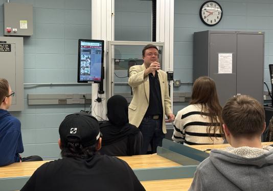 Professor showing item to high school student tour