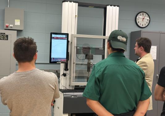 Professor showing machine to high school students
